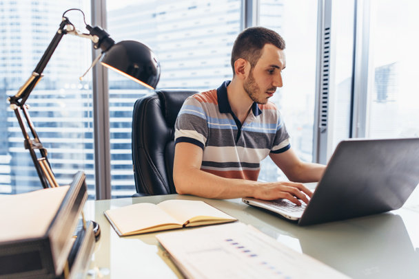 Бизнесмен, работающий на ноутбуке с помощью интернета, ищет информацию, сидя за столом в офисе
 - Фото, изображение