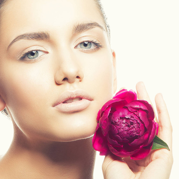 retrato de mujer joven con maquillaje natural y flor de peonía sobre fondo blanco
 - Foto, Imagen