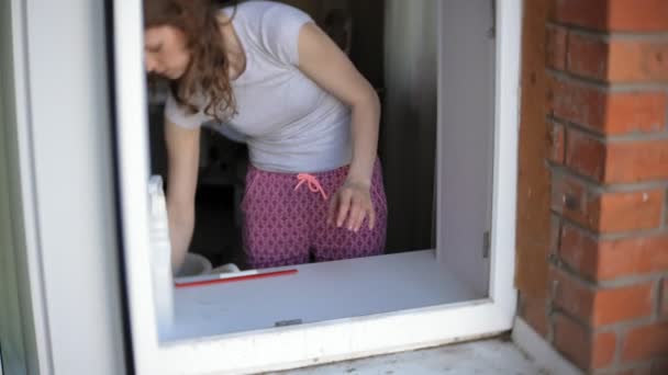 attractive girl washes windows at home. To clean up the house. - Πλάνα, βίντεο