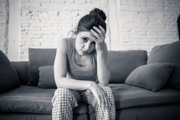 Beautiful latin depressed lonely woman staring out feeling sad, pain, grief at home on her sofa. Crisis, depression and mental health concept - Foto, imagen