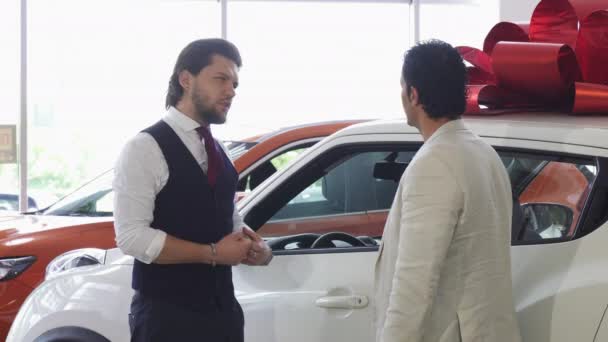 Professional car salesman opening door of a car for his male customer - Footage, Video