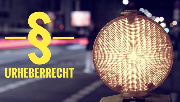 Bouw website lamp en traffic's nachts met de inscriptie in Duitse Urheberrecht in Engelse verduidelijking van het auteursrecht - Foto, afbeelding