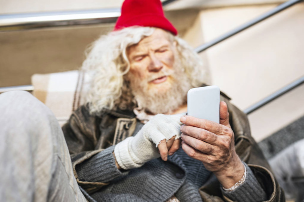 Nice bearded man pressing a smartphone screen - Foto, afbeelding