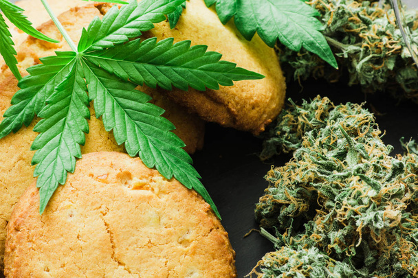 CBD Cookies with cannabis and buds of marijuana on the table. - Photo, Image