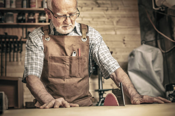 professional carpenter works with a saw bench in his workshop - Foto, imagen