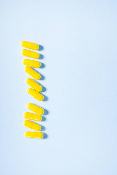 Yellow capsules on blue - Фото, изображение