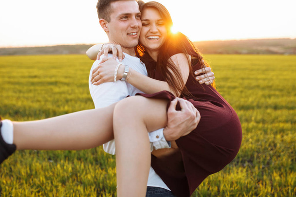 junges, glückliches, liebevolles Paar, im Freien, Mann hält ein Mädchen auf dem Arm und genießt einander, Werbung, - Foto, Bild