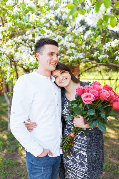 young loving couple in love, girl holding flowers, happy and enjoy the beautiful nature, advertising, - Fotografie, Obrázek
