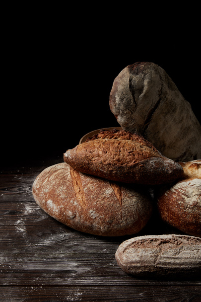 closeup view of various types of bread on wooden table covering by flour - Fotografie, Obrázek