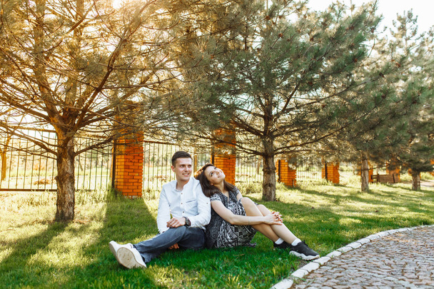 młode, szczęśliwe, loving para, siedzieli na trawie w parku i cieszyć się sobą, reklama, - Zdjęcie, obraz