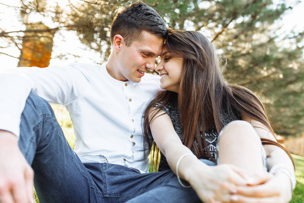 young, happy, loving couple, sitting together on the grass in the Park, and enjoying each other, advertising, - Photo, Image