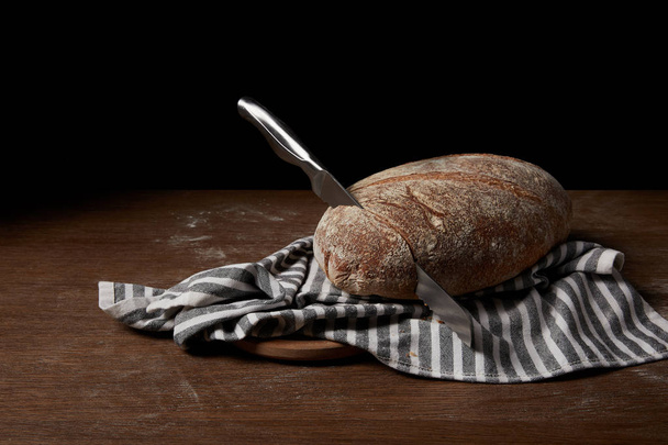 Close-up beeld van brood, zak, mes en snijplank op tafel - Foto, afbeelding