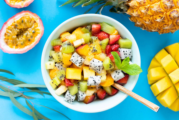 Fruit salad with tropical and exotic fruits on blue background - Foto, Imagem