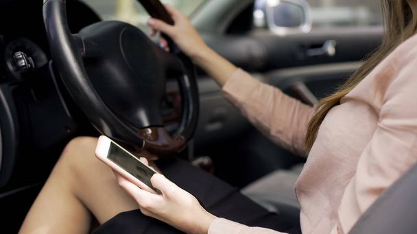 Businesswoman sitting in car and reading news on smartphone, mobile application - Foto, Imagen