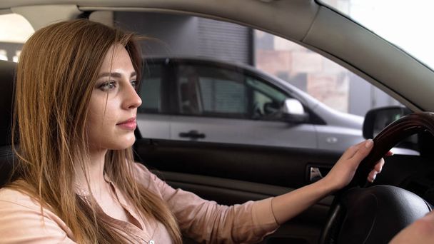 Young woman driving out from parking place, steering confident, attentive - Foto, immagini
