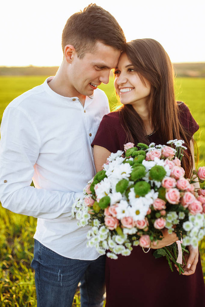 young happy couple in love, girl holding flowers, happy and enjoy each other's company, advertising, - Foto, Imagen