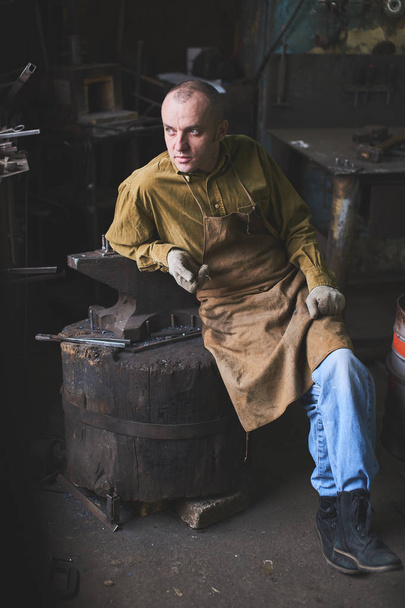 Portrait of a forge taking rest in the workshop - 写真・画像
