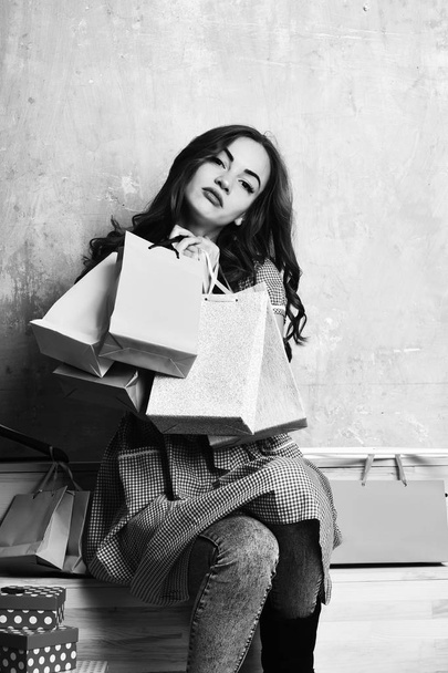 pretty sexy woman with shopping bags, boxes, hangers on stairs - Photo, image
