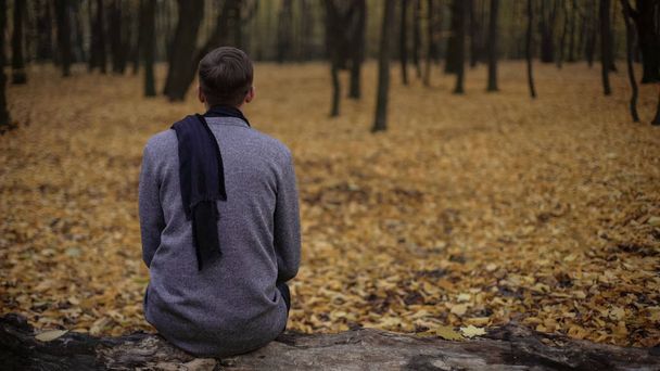 Man sitting in park alone, gray tones express depression, sadness, melancholy - Foto, imagen