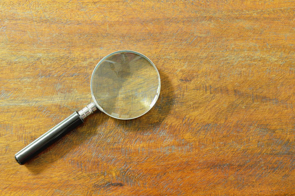  magnifying glass with black handle on wooden table background - Photo, Image