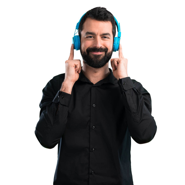 Jóképű férfi szakáll hallgat zenét a fehér háttér - Fotó, kép
