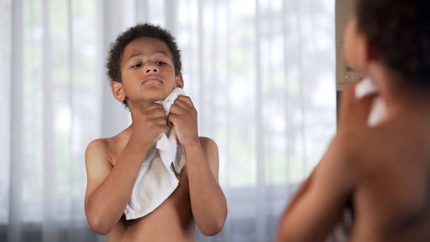 Afro-American kid doing morning hygiene, healthy lifestyle, wiping by towel - Foto, Imagen