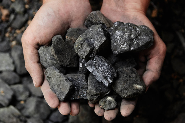 Szénbányász szén háttér ember kezében. Szén bányászat vagy energia forrás, környezetvédelem. Ipari parazsat. Vulkáni rock. - Fotó, kép