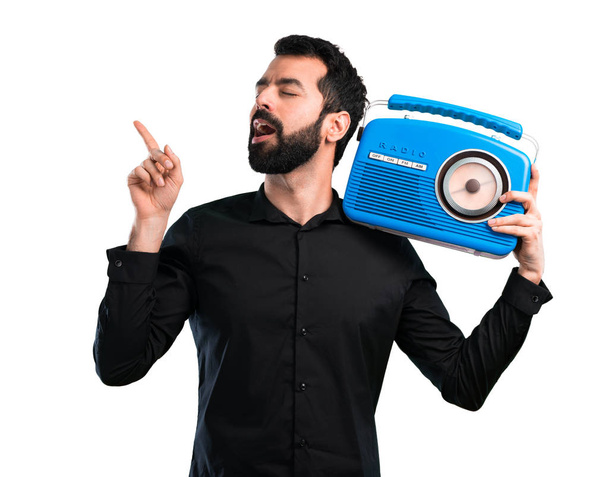 Hombre guapo con barba sosteniendo una radio sobre fondo blanco
 - Foto, imagen