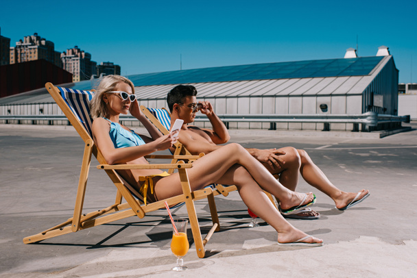 young couple relaxing on sun loungers relaxing on parking - Photo, Image