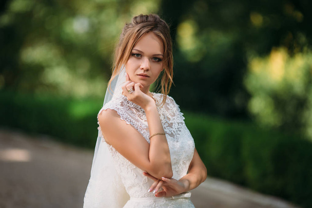 The beautiful blonde is getting married. Portrait of a young girl in a lace wedding dress. - Foto, afbeelding