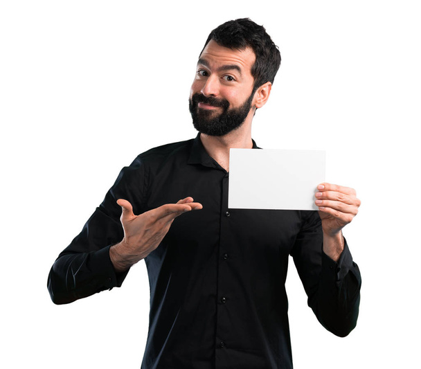 Handsome man with beard holding an empty placard on white background - Photo, Image