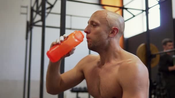 Moe zweterige fitness man drinkwater uit de fles na de training in de sportschool - Video