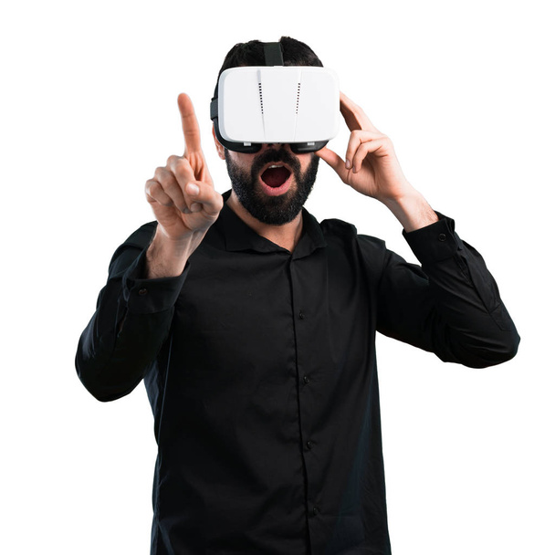 Homem bonito com barba usando óculos VR no fundo branco
 - Foto, Imagem