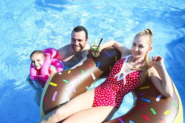 Ευτυχισμένη οικογένεια που διασκεδάζει στην πισίνα - Φωτογραφία, εικόνα