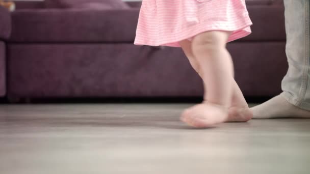 Menina fazendo os primeiros passos em sua vida. Caminhada de aprendizagem infantil. Pequenos pés passo - Filmagem, Vídeo