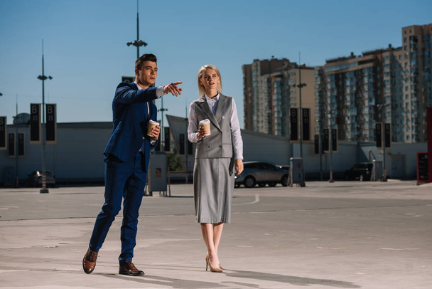 young attractive business couple with coffee to go on parking - 写真・画像