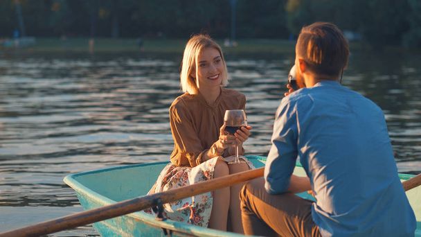 Mladý pár se sklenkami vína v loďce - Fotografie, Obrázek