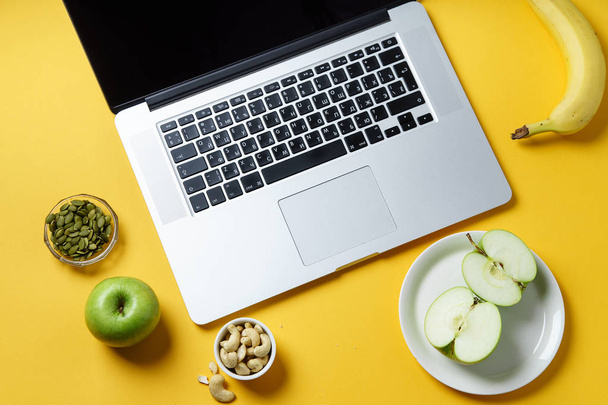 laptop and healthy snacks on yellow background, Modern lifestyle concept  - Foto, afbeelding