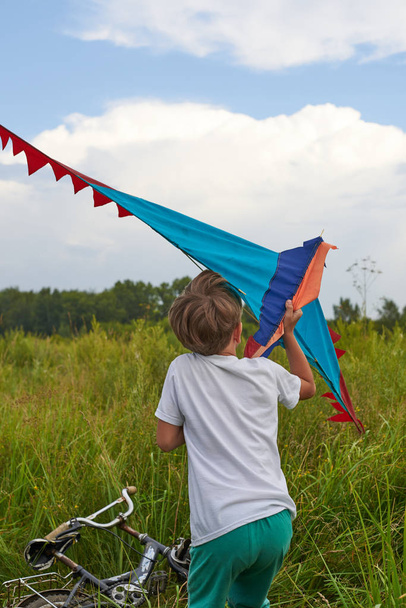 De man probeert te lanceren een vliegende kite in de lucht. Kleurrijke lichte vliegmachine. - Foto, afbeelding