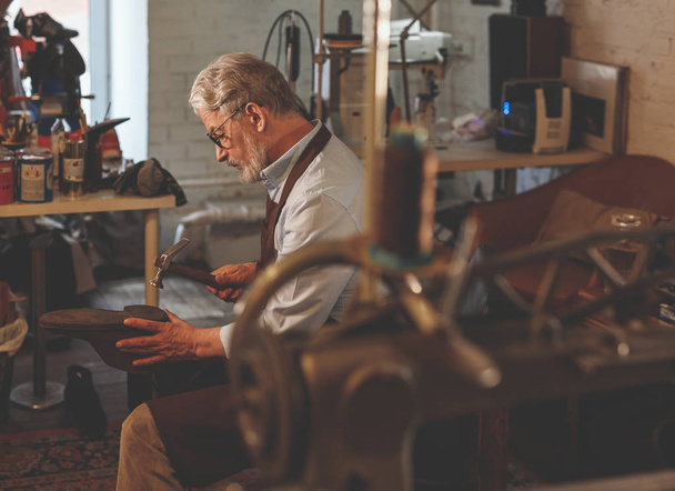 Elder cobbler at work in the workshop - Photo, Image