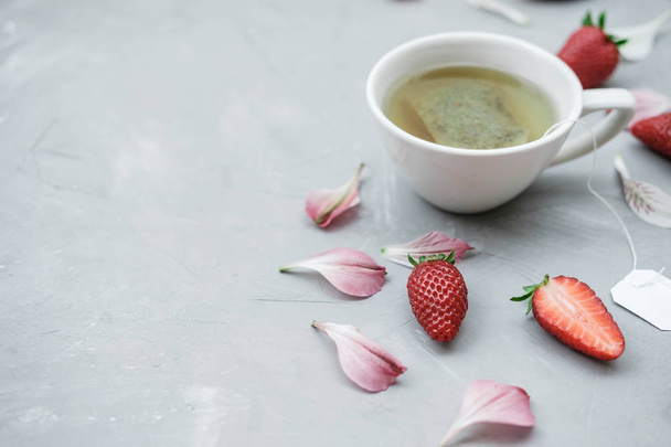 Slices of strawberries and herbal tea on a gray background - Fotografie, Obrázek