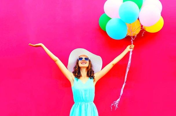 Cool girl with an air colorful balloons is having fun in summer over pink background - Foto, Imagem