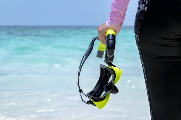 Woman on the beach and Swimsuit a pink.Holding Goggles,scuba diving Black-yellow - Fotografie, Obrázek