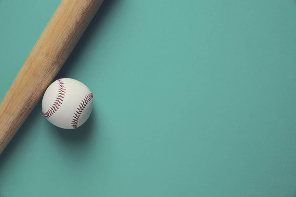 baseball and baseball bat on green background, close up - Foto, Imagen