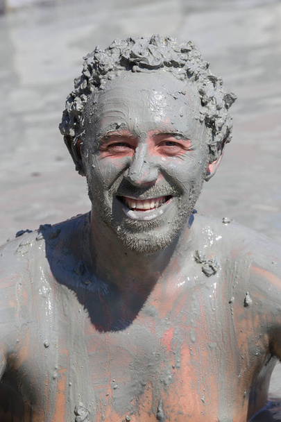 Mud treatment at the Dalyan, Turkey. Portrait happy man who takes a mud bath, close up - Foto, Imagen