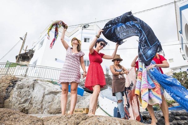 Пять цветных какуазианских женщин-друзей готовят парео на день на пляже на Тенерифе. группа людей в дружбе и отношениях активный отдых на открытом воздухе под солнечным светом в отпуске
 - Фото, изображение