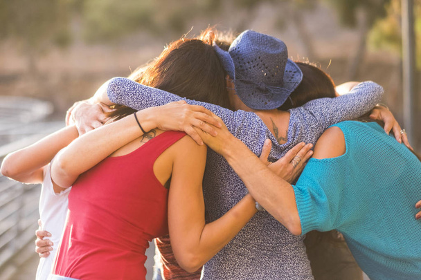 Союз всех вместе, как командная работа и группа друзей женщин 7 красивых женщин обнимают все вместе под солнечным светом и закатом для дружбы и отношений и концепции успеха. вневременные друзья
. - Фото, изображение