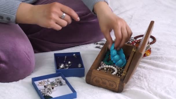 Detailní záběr rukou žena vázajícího řetězce s korálky a dělat náramek - Záběry, video