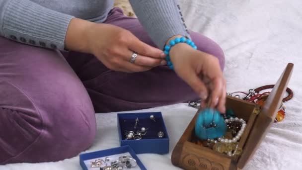 Close up van handen van vrouw gelijkmakende string met parels en armband maken - Video