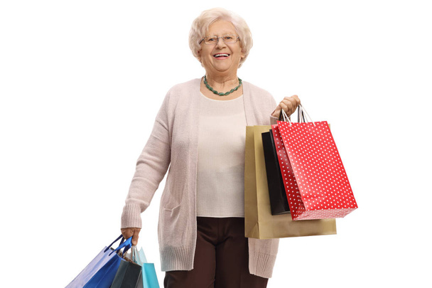 Mature woman with shopping bags isolated on white background - Фото, изображение